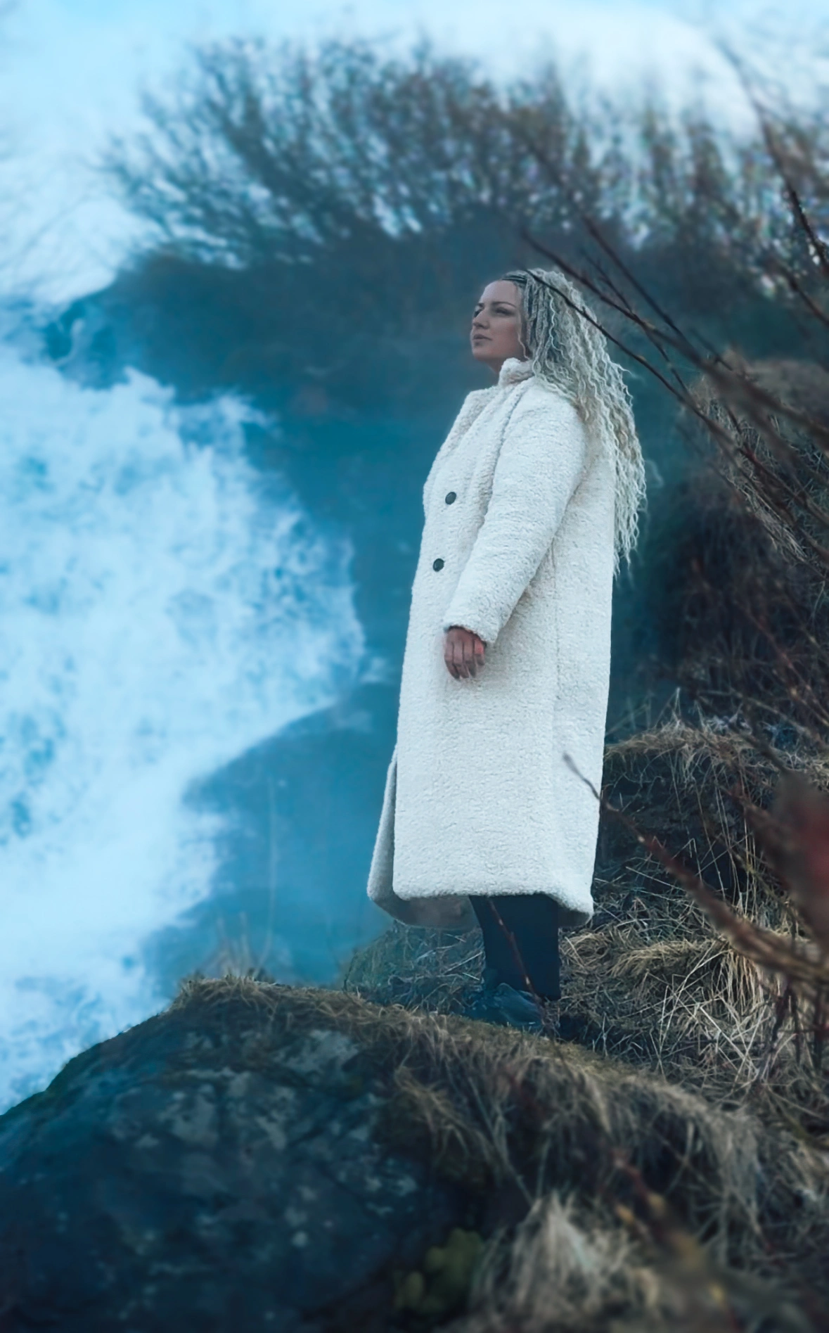 Woman standing in front of a waterfall in Iceland