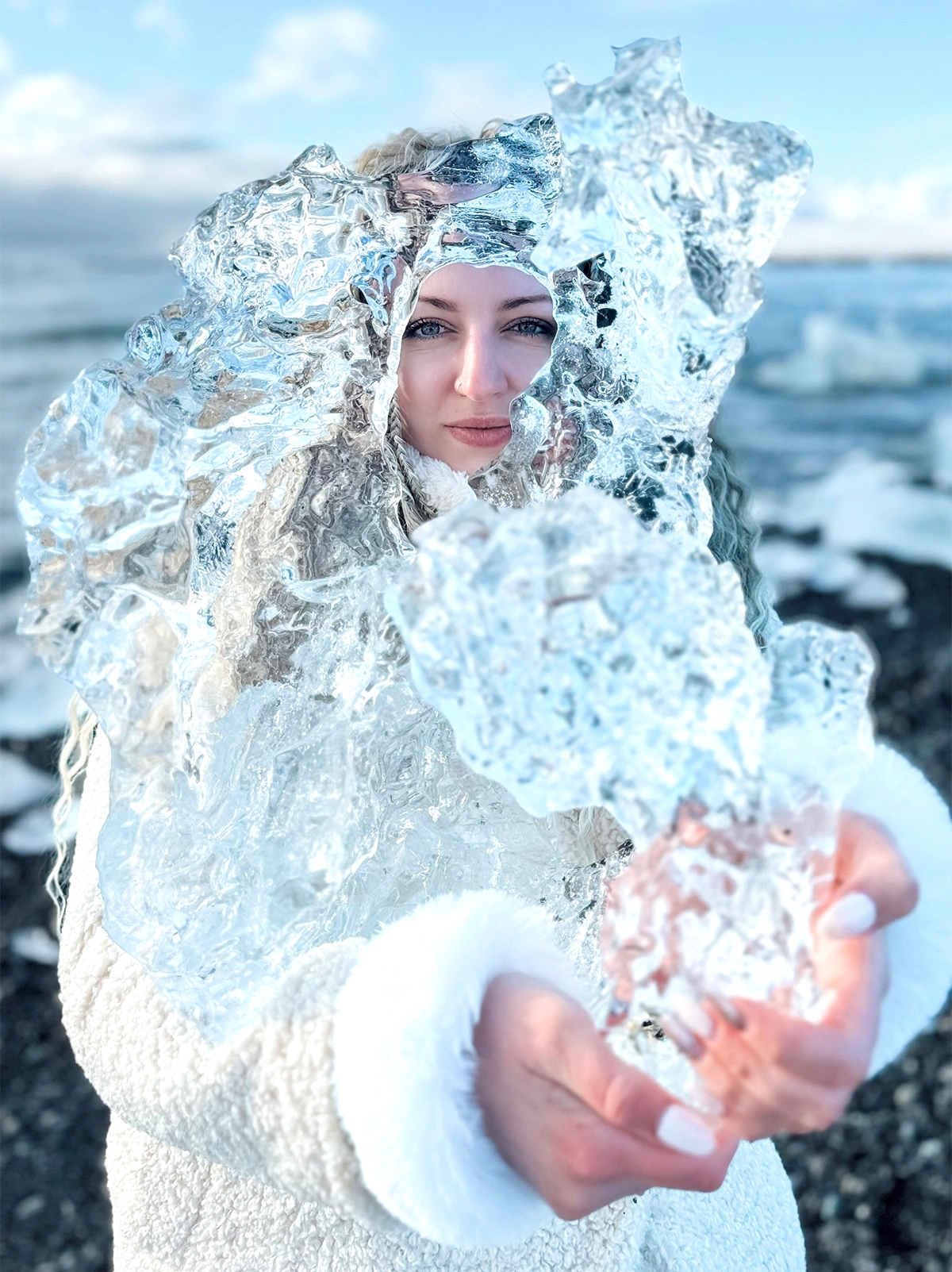 Women holding big ice chunk at Diamond beach in Iceland
