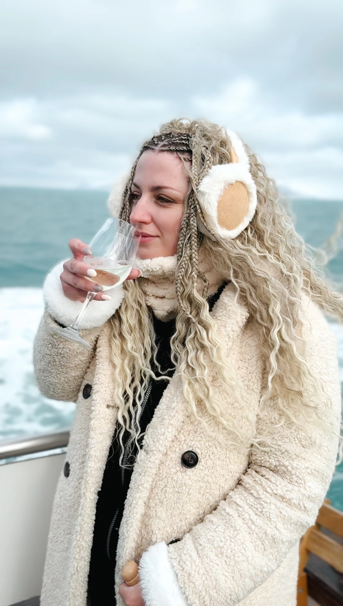 Woman sipping white wine on a boat in a whale watching tour in Iceland